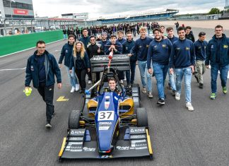 MoRe Modena Racing team members walking behind their car on the pit straight of Silverstone circuit